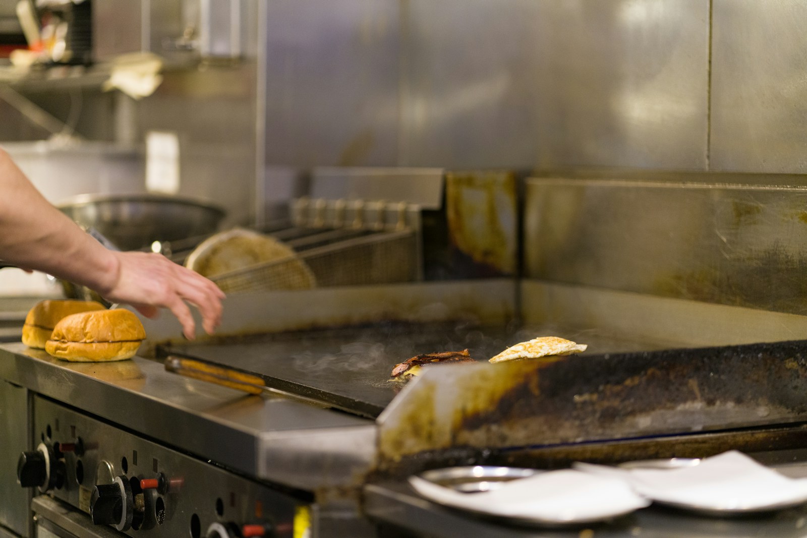 Cocinero trabajando en la plancha caliente de un restaurante