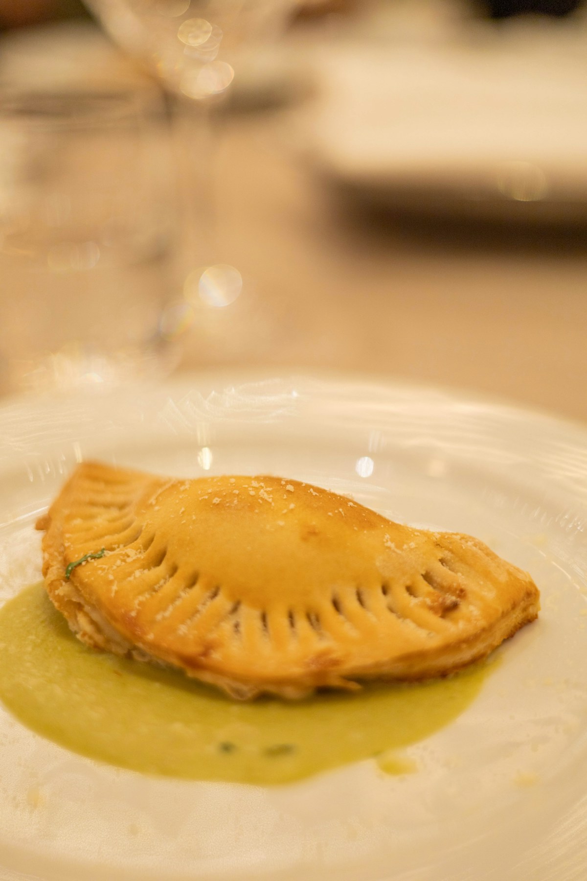 Empanada dorada servida con salsa verde