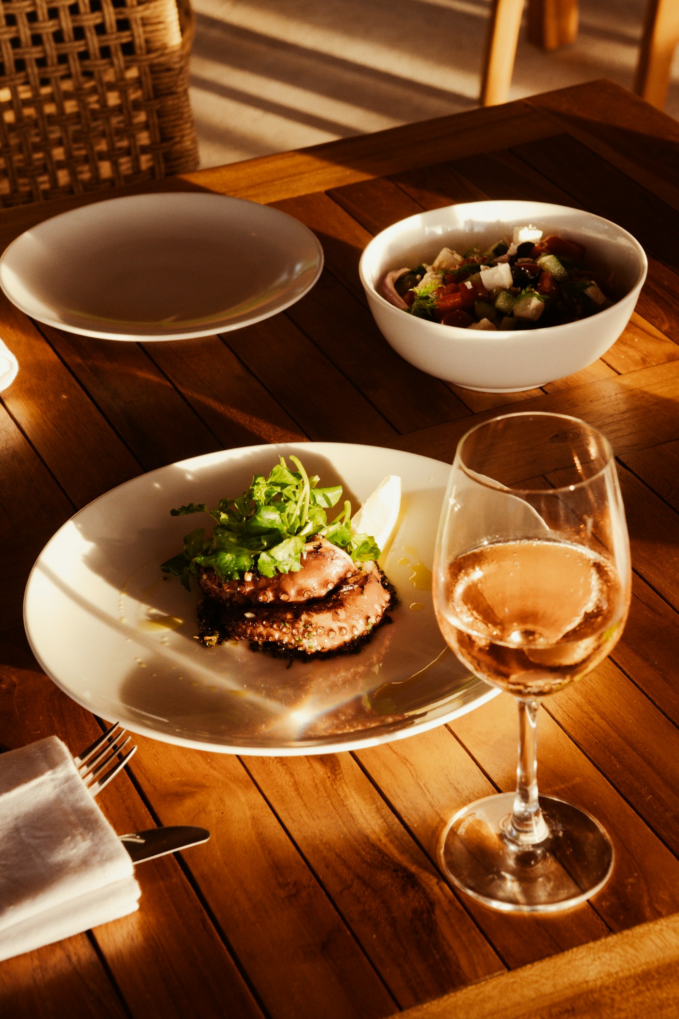 Pulpo a la brasa servido con ensalada y vino